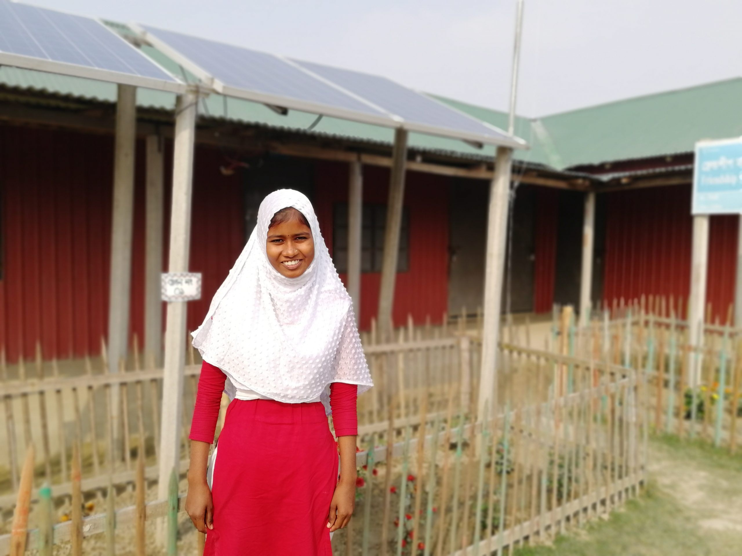 Alphona framför solcellerna på hennes skola