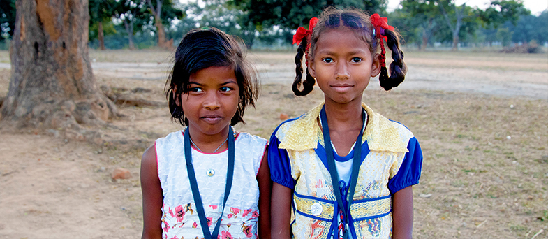 Alphona står framför sin skola i Bangladesh