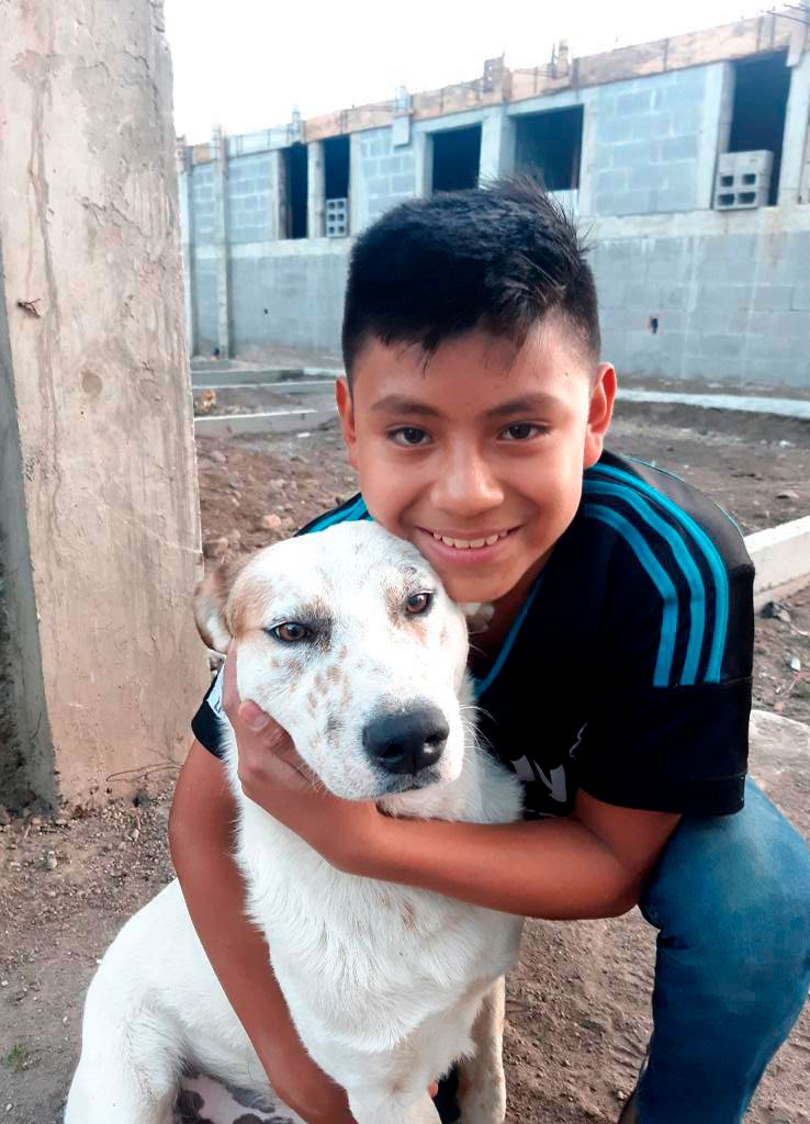Cristian från Guatemala kramar sin vita hund Silke