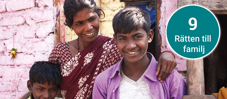En familj i Indien står framför en lila tegelvägg
