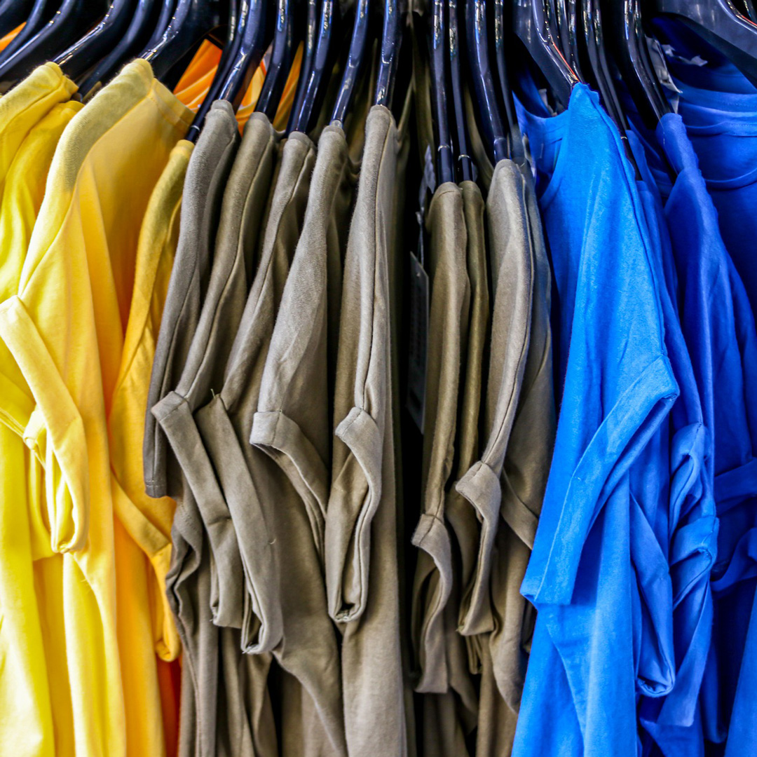 Mängder av t-shirtar i gult, grått och blått